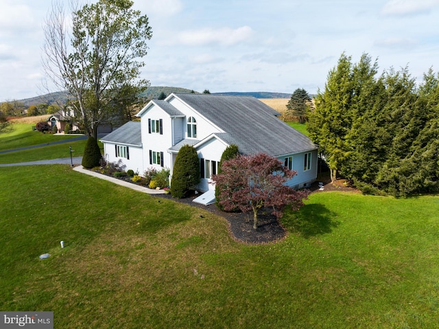 view of side of home with a yard