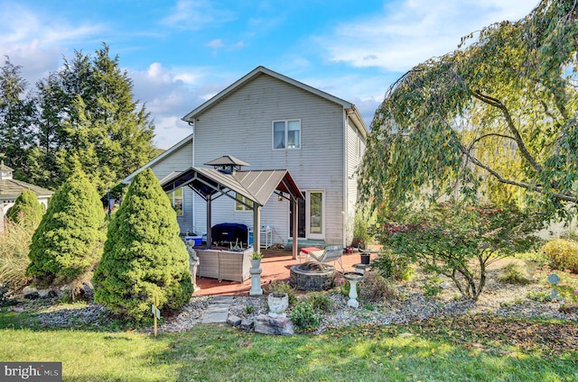 rear view of house featuring a fire pit, a gazebo, and a patio area