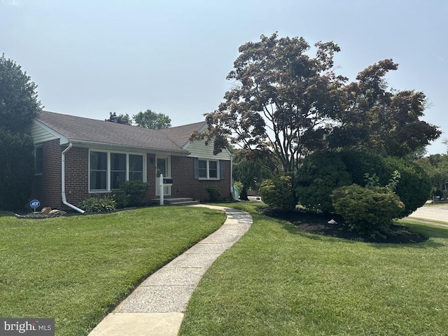 view of front facade featuring a front yard and brick siding