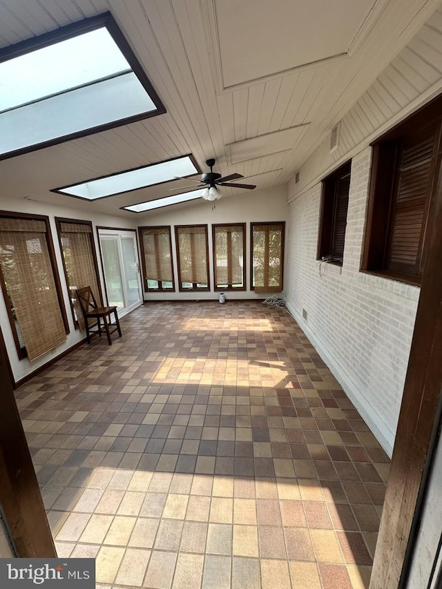 unfurnished sunroom featuring ceiling fan, vaulted ceiling with skylight, and wood ceiling