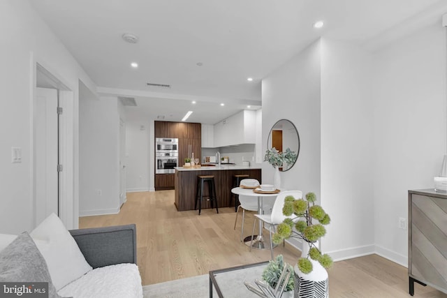 living room featuring light hardwood / wood-style flooring and sink