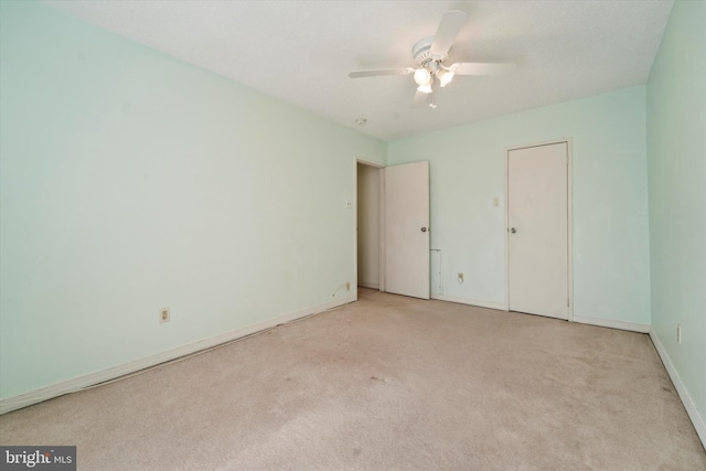 unfurnished bedroom with ceiling fan and light colored carpet