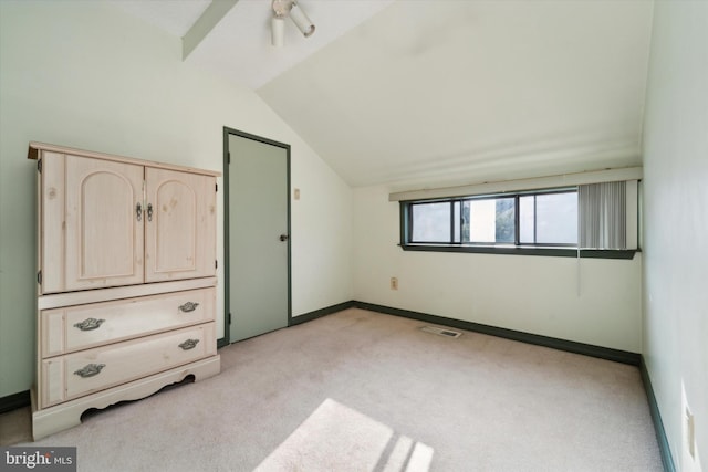 unfurnished bedroom with vaulted ceiling and light carpet