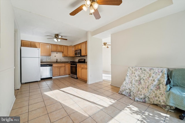 kitchen featuring appliances with stainless steel finishes, decorative backsplash, light tile patterned flooring, ceiling fan, and sink