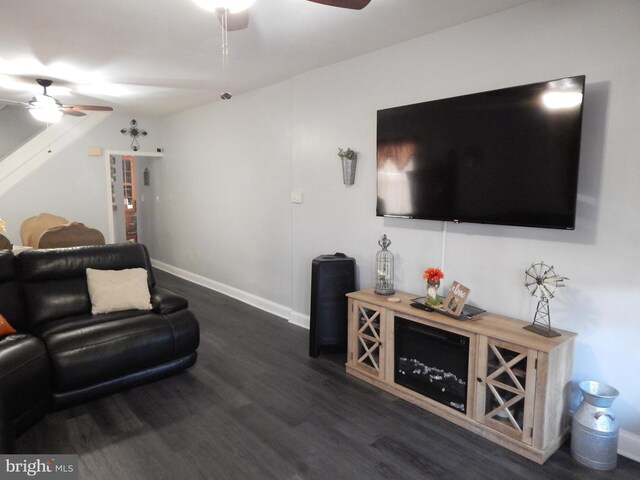 living room with dark wood-style floors, baseboards, and a ceiling fan