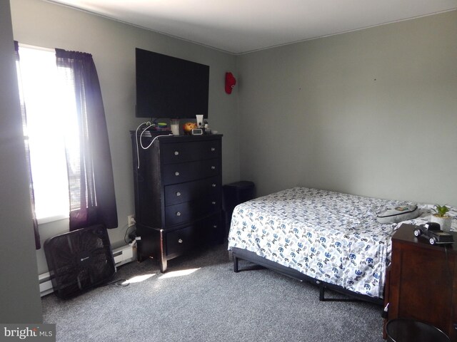 bedroom featuring carpet floors, a baseboard heating unit, and multiple windows