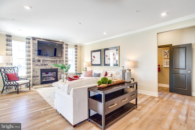 living room with a fireplace, ornamental molding, and light hardwood / wood-style flooring