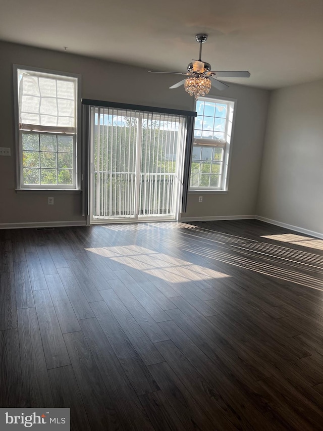 spare room featuring ceiling fan and dark wood-type flooring