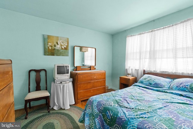 bedroom featuring multiple windows and hardwood / wood-style floors