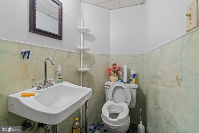 bathroom featuring tile walls and toilet