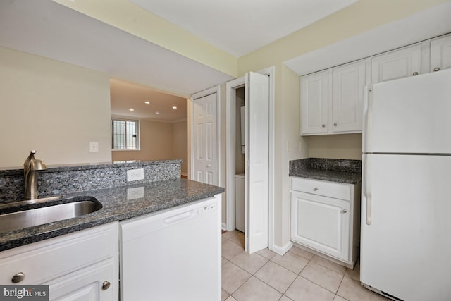 kitchen featuring white appliances, light tile patterned floors, white cabinets, sink, and dark stone counters