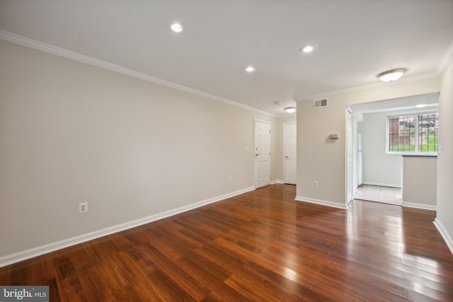 empty room featuring crown molding and dark hardwood / wood-style floors