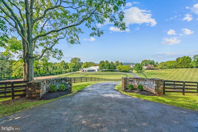 view of gate featuring a yard and a rural view