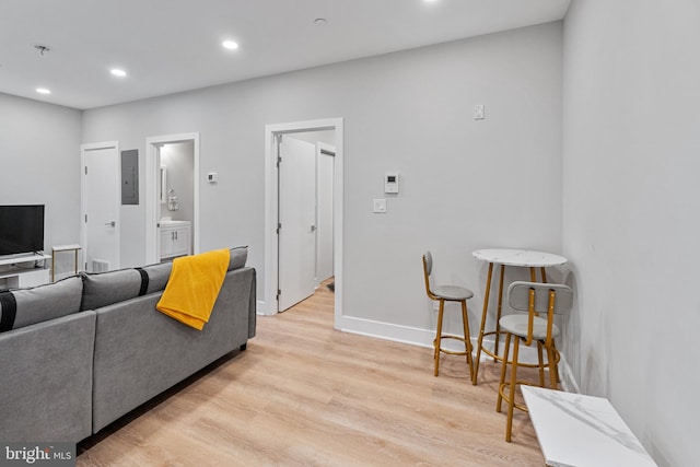 living room featuring electric panel and light hardwood / wood-style flooring