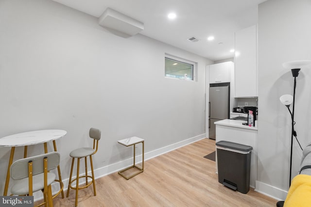 home office with light hardwood / wood-style flooring