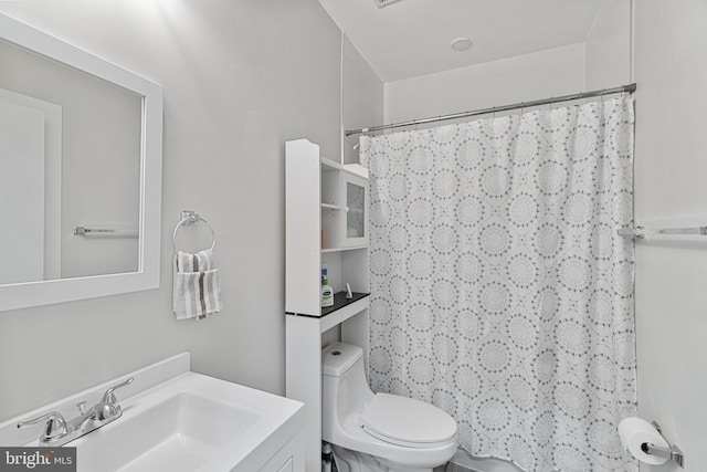 bathroom with walk in shower, toilet, and vanity