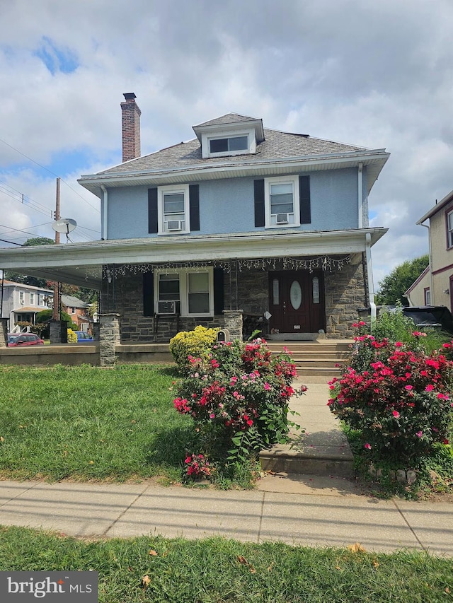 view of front of property with covered porch and a front yard