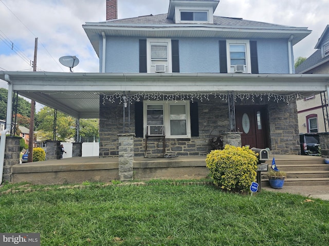 view of front of home with a porch and a front yard