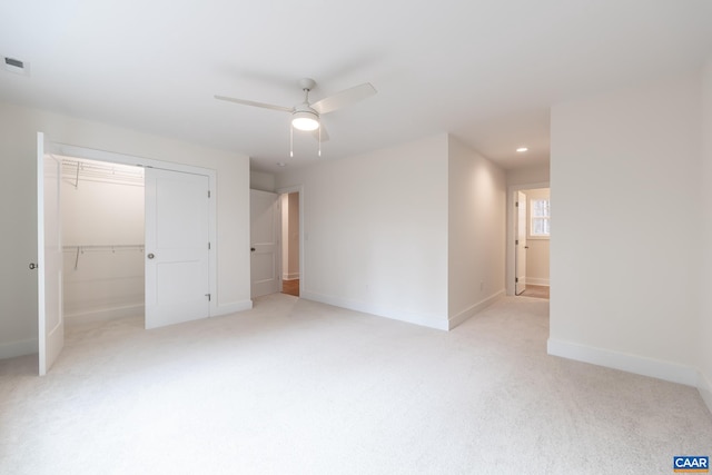 unfurnished bedroom featuring light carpet, a closet, recessed lighting, and baseboards