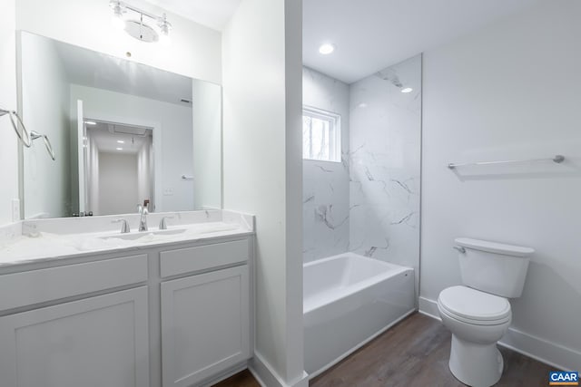 bathroom featuring shower / tub combination, toilet, wood finished floors, vanity, and baseboards