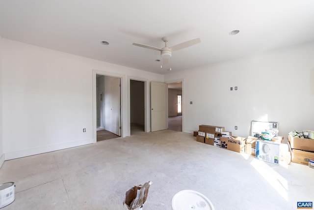 interior space with a ceiling fan and baseboards