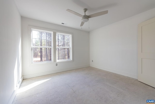 unfurnished room featuring a ceiling fan, visible vents, concrete floors, and baseboards