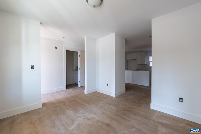 unfurnished living room featuring baseboards and wood finished floors