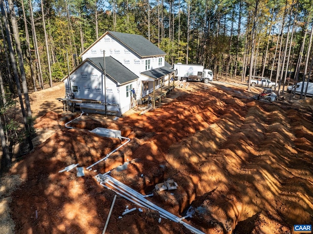 exterior space featuring roof with shingles and a view of trees