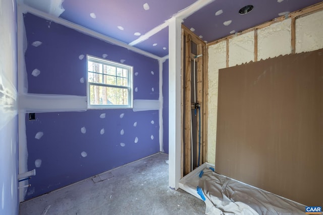 unfurnished bedroom with unfinished concrete flooring