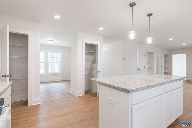 kitchen with light wood-style flooring, built in shelves, white cabinets, and recessed lighting