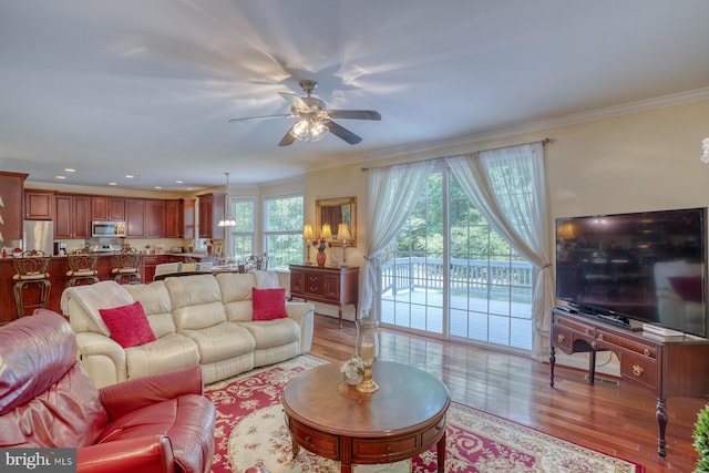 living room with crown molding, ceiling fan, and light hardwood / wood-style floors