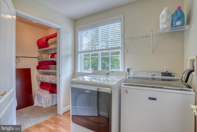 washroom featuring washing machine and clothes dryer, laundry area, and light wood-type flooring