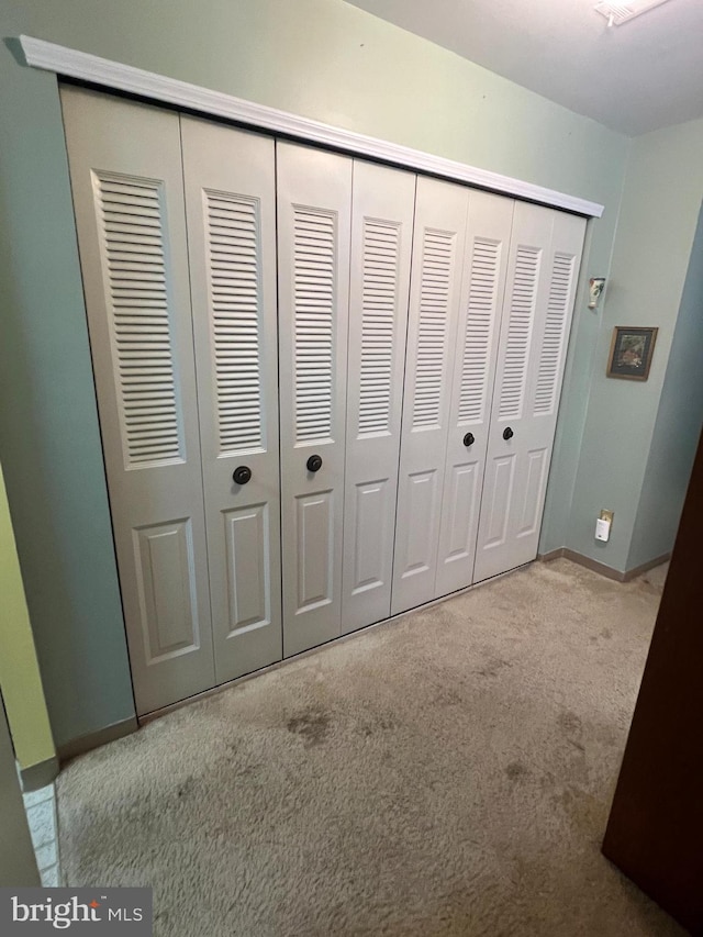 unfurnished bedroom featuring a closet, baseboards, and carpet floors