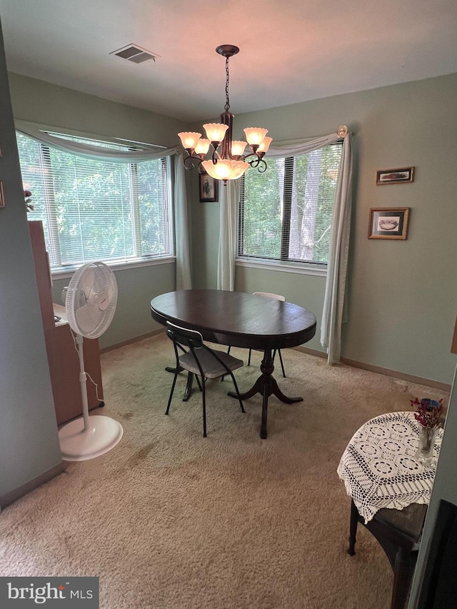 dining area featuring a notable chandelier, plenty of natural light, and light carpet