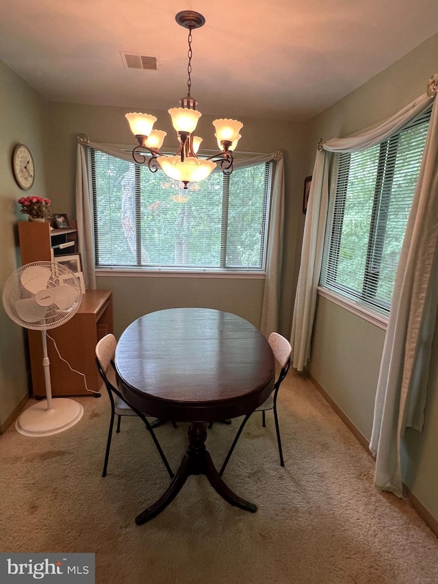 dining area featuring visible vents, baseboards, light colored carpet, and an inviting chandelier