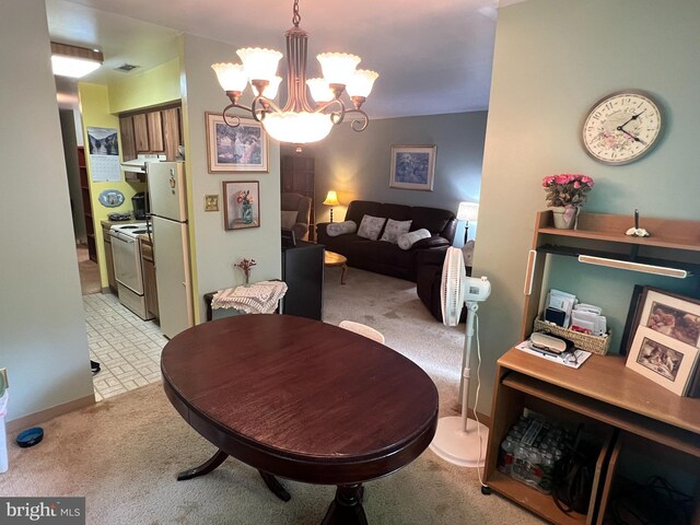 dining space featuring light colored carpet and a chandelier