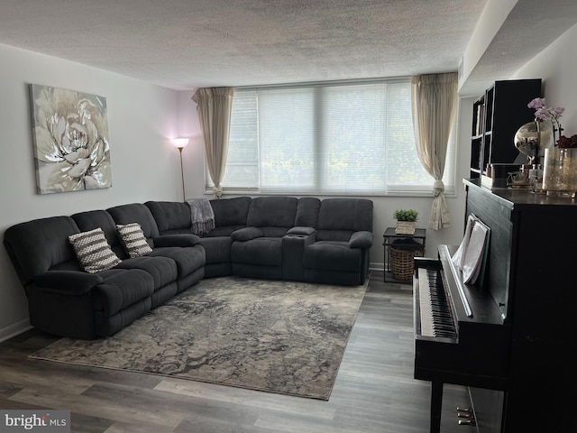 living area with wood finished floors, baseboards, and a textured ceiling