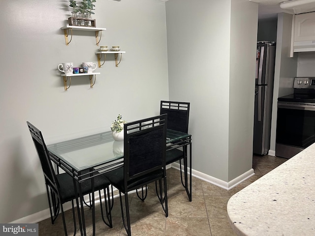 dining area featuring baseboards and light tile patterned flooring