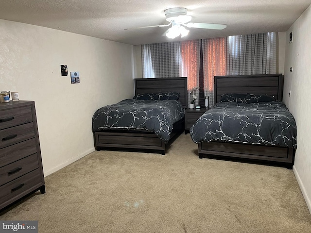 carpeted bedroom with ceiling fan, a textured ceiling, and baseboards