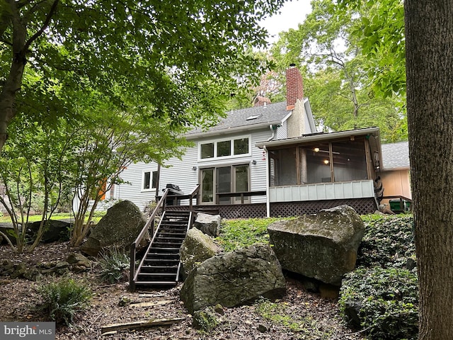 rear view of property featuring a sunroom