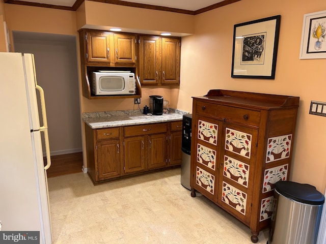 kitchen featuring crown molding and white appliances