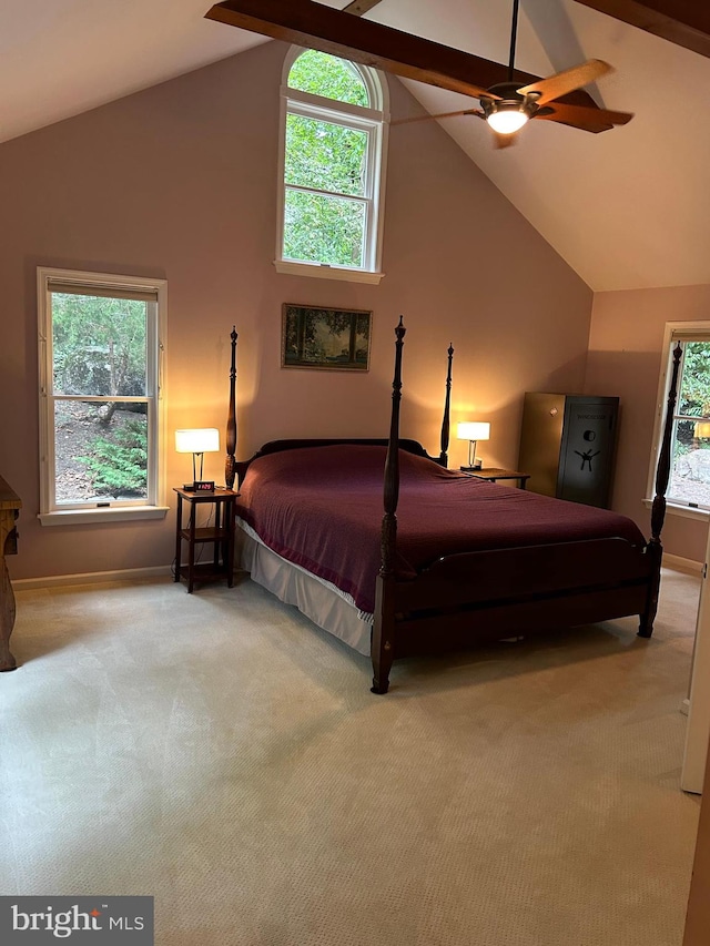 carpeted bedroom featuring multiple windows, ceiling fan, and beam ceiling