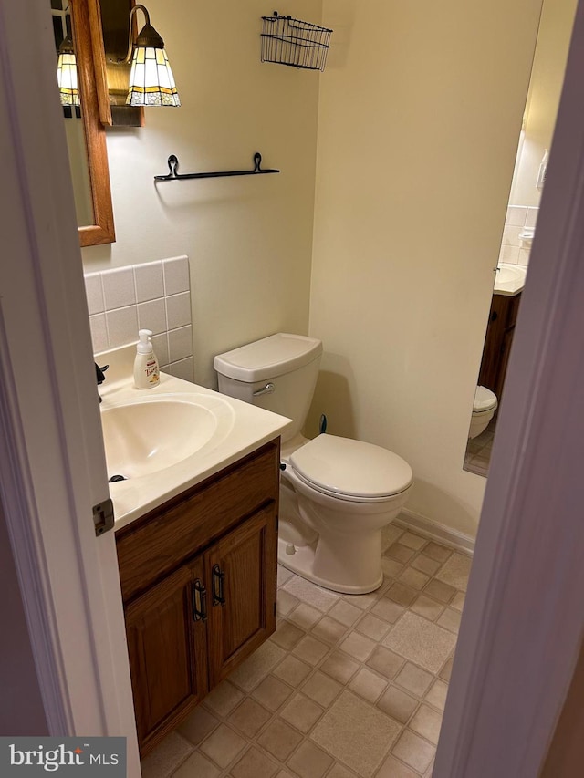 bathroom with vanity, toilet, and backsplash