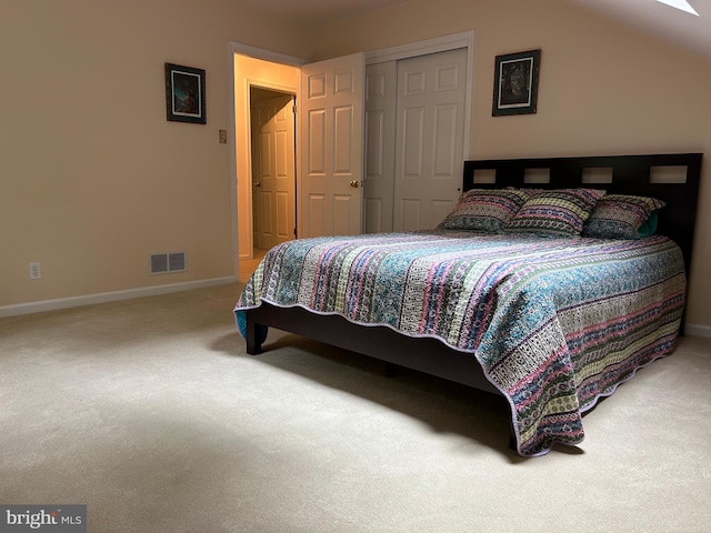 carpeted bedroom with a closet and vaulted ceiling