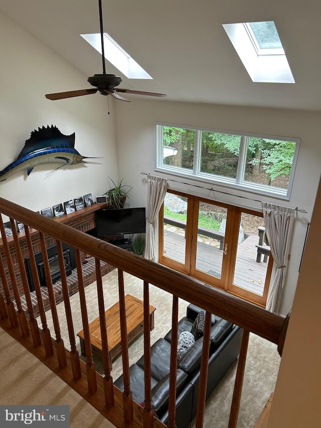 staircase featuring ceiling fan and a skylight