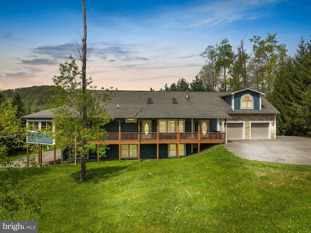 view of front of house with a lawn, a garage, and a deck