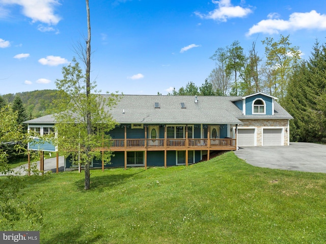 rear view of house featuring a garage, a deck, and a lawn