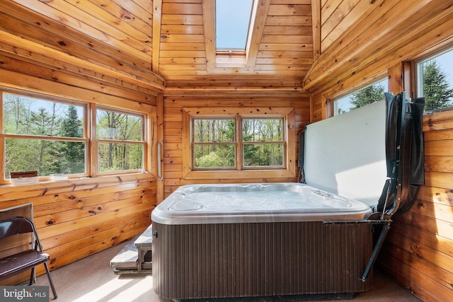 interior space featuring vaulted ceiling with skylight and a hot tub