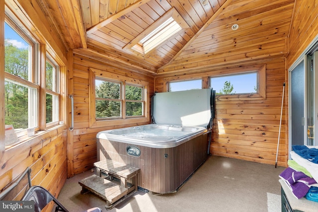 interior space with wooden ceiling, vaulted ceiling with skylight, and a hot tub