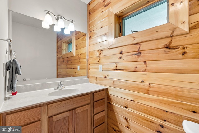 bathroom featuring vanity, toilet, and wooden walls